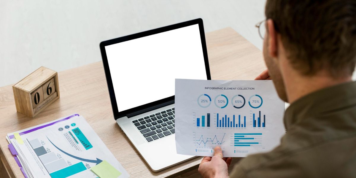 Close-up of a person's hands holding a black smartphone with a cracked screen over a blue mat